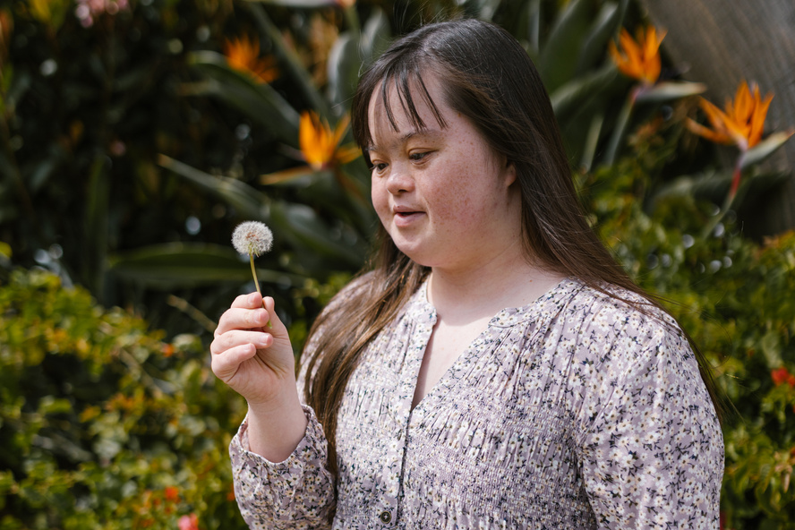 Woman in Floral Top Holding White Dandelion